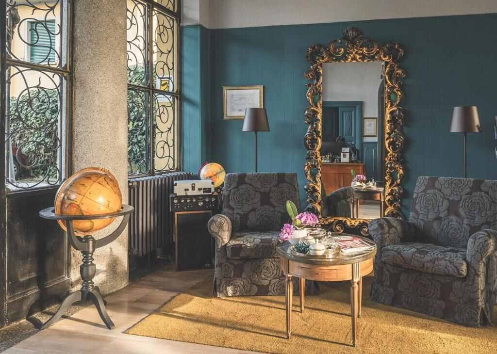 Lounge of Hotel Villa Aurora with antique mirror and armchairs